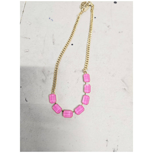 Necklace with pink beads on a gold chain against a light gray background