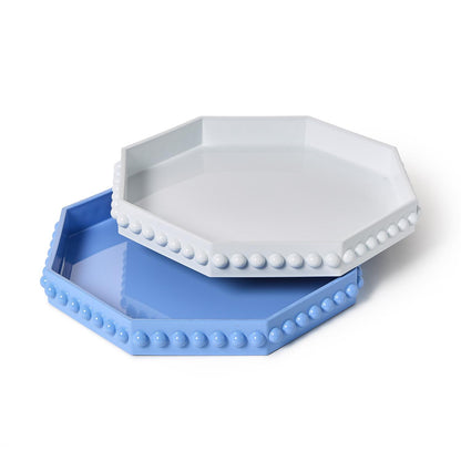 Hexagonal blue and white trays with bead detailing on a white background