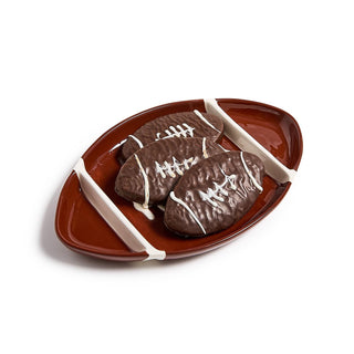 Chocolate football-shaped cookies on a decorative plate shaped like a football.