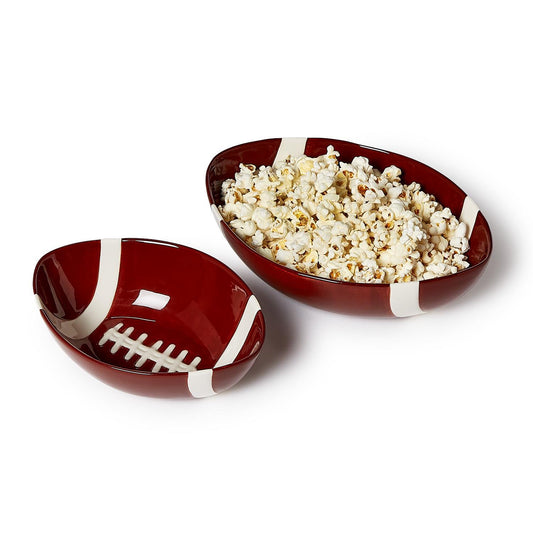 Two football-shaped bowls with popcorn on a white background