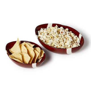 Two football-shaped bowls filled with popcorn and tortilla chips on a white background