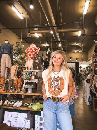 Woman standing in a clothing store with various items on display