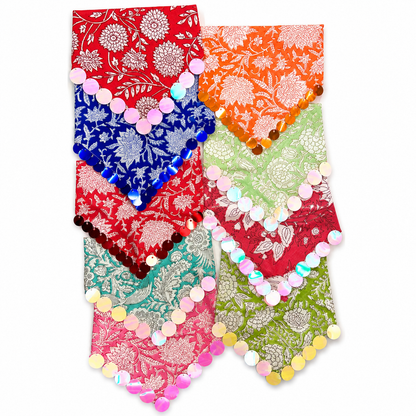 A set of six colorful floral patterned fabric neckties or waist ties arranged in two columns on a white background. Each tie features a different vibrant base color (red, orange, blue, green, pink, and teal) with a metallic silver or gold brocade-style floral pattern and a row of iridescent round sequins along the edge.