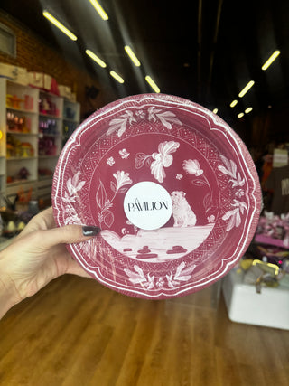 A pack of round decorative paper plates featuring a vintage-style illustration in white on a maroon background. The design includes a seated bulldog, flowers, butterflies, birds, and ornamental border motifs.