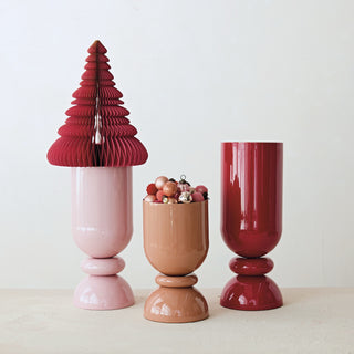 Three decorative vases in pink, brown, and red on a white background
