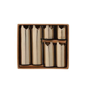 A set of six metallic cylindrical tools or inserts arranged in a brown cardboard tray on a plain white background.