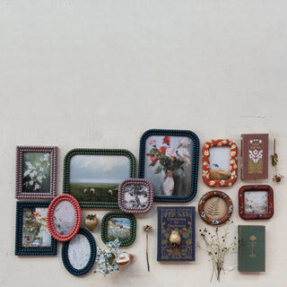 Collection of decorative picture frames and books on a light surface