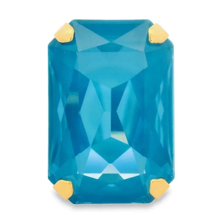 Blue gemstone with gold prongs on a white background