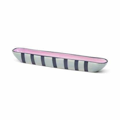 Long, narrow ceramic dish with pink and blue striped design on a white background