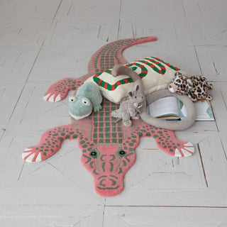 Children's rug shaped like a crocodile with toys on a light wooden floor