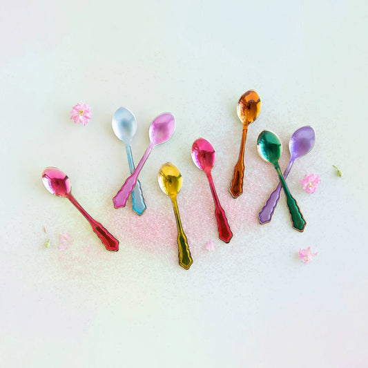 Colorful spoons on a light background with small flowers.
