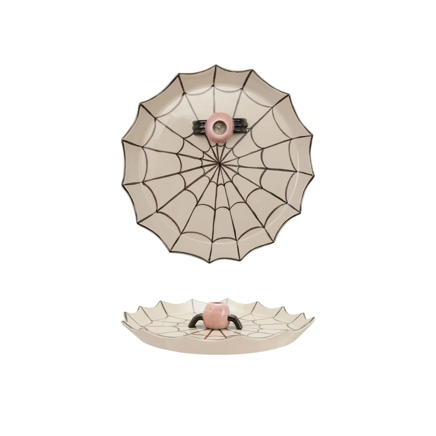 A ceramic spiderweb-themed dish with a scalloped rim, featuring a top-down view of a spiderweb pattern with a pink center and a bottom view showing a small raised spider face at the hub.