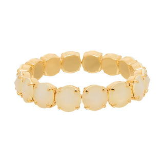 A gold-plated stretch bracelet featuring a row of round, faceted cream cabochon stones set in gold, shown against a plain white background.