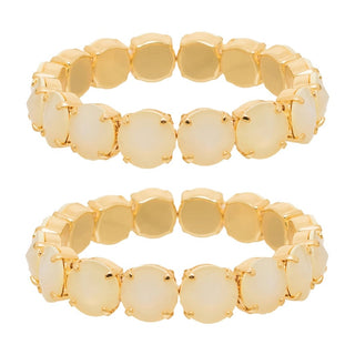 Two gold-plated stretch bands, each featuring a row of round, dome-shaped cream-colored cabochon gemstones, displayed against a solid white background.