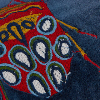 Close-up of embroidered fabric with circular patterns on a dark blue background