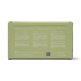 The back of a sage green box for a wellness product, showing three columns of white text for Lavender Lemon, Molletta, and Blackberry Basil, along with a small QR code, on a white background.