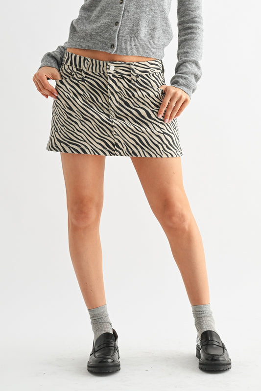 Person wearing a zebra print skirt with a plain background