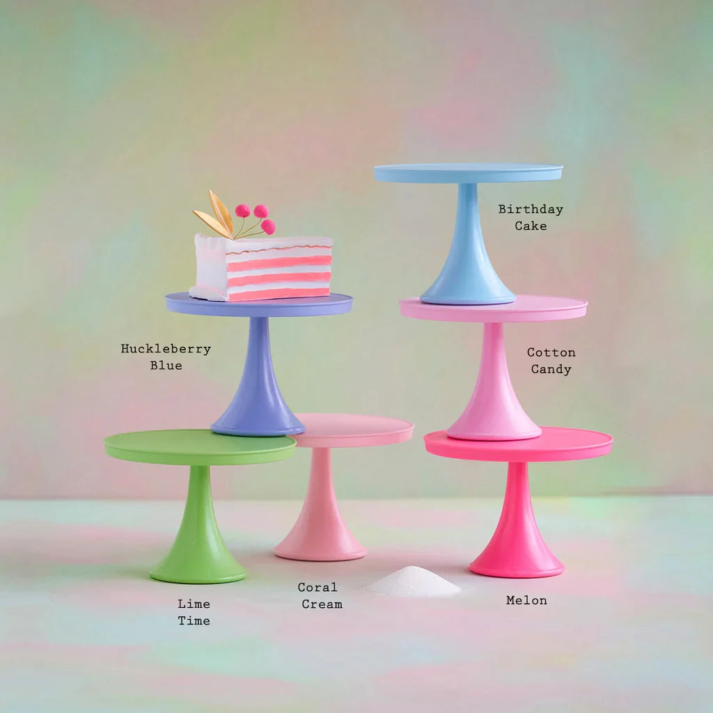 Set of colorful cake stands with a small cake on a pastel background