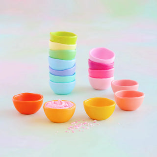 A stack of colorful melamine trinket bowls with a rainbow ombre effect.