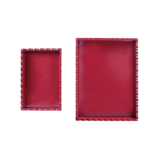 Two red rectangular trays with decorative edges on a white background