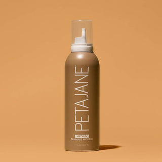 A bottle of PETA Jane Hair Serum in the Warm Brown shade, standing upright on a solid warm brown background.