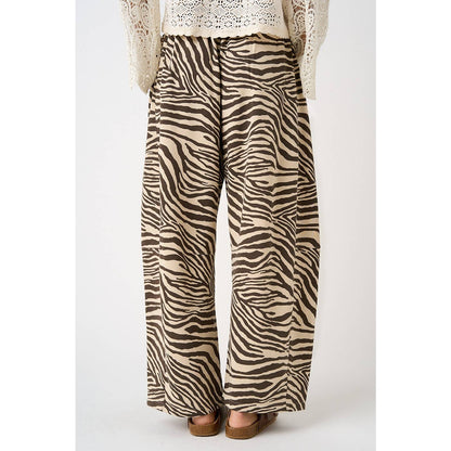 Zebra print pants worn with a white lace top on a white background