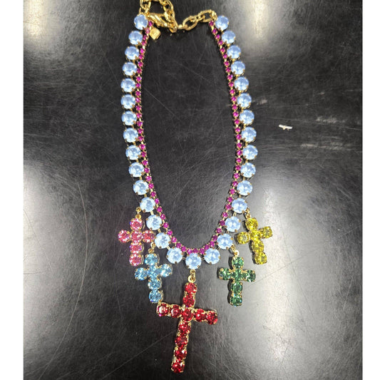 Necklace with colorful cross pendants on a reflective surface